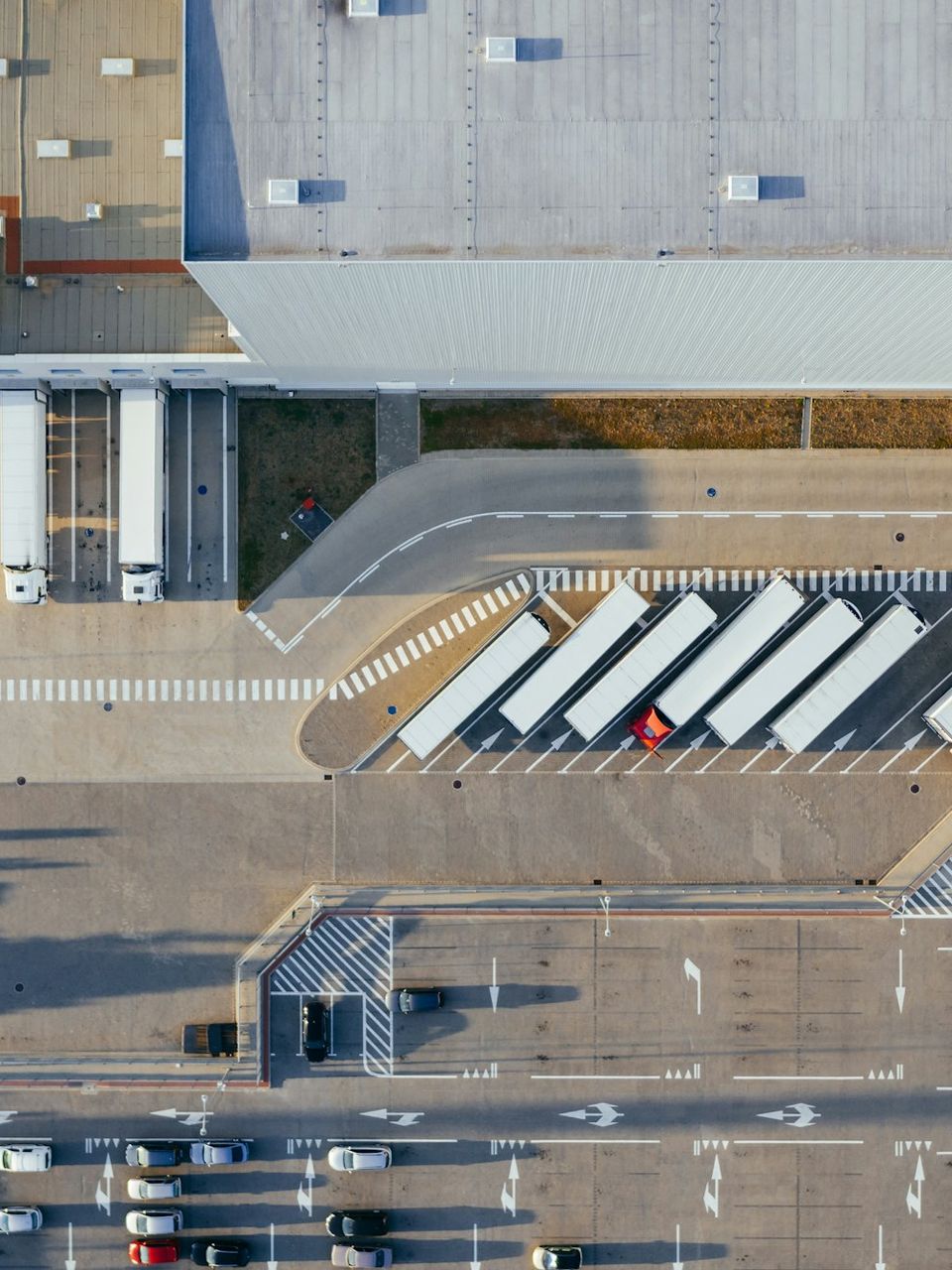 Vista aérea de grande complexo logístico com docas e caminhões